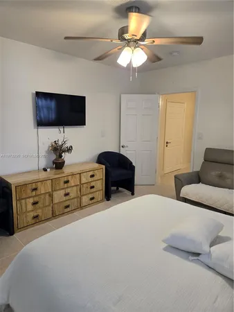 a bedroom with a bed a chandelier and a dresser