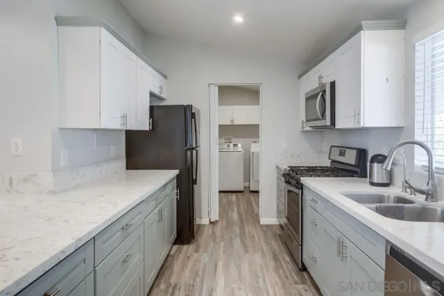 a kitchen with stainless steel appliances granite countertop a sink stove and refrigerator