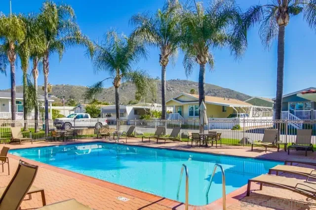a view of swimming pool with outdoor seating and a garden