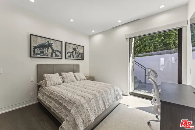 a bedroom with a large bed and a large mirror