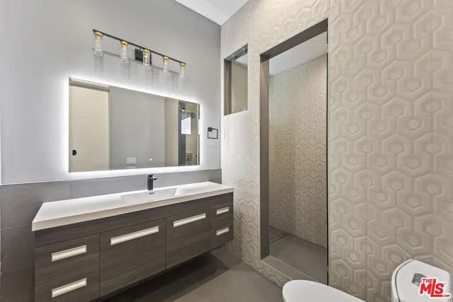 a bathroom with a double vanity sink mirror and shower