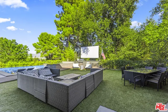 a view of a house with backyard and sitting area