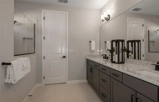 a spacious bathroom with a granite countertop sink and a mirror