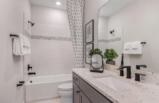 a bathroom with a granite countertop sink a toilet and bathtub