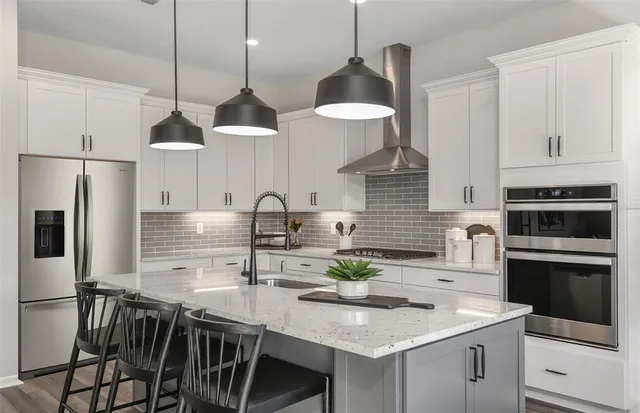 a kitchen with stainless steel appliances granite countertop a sink a stove and a refrigerator