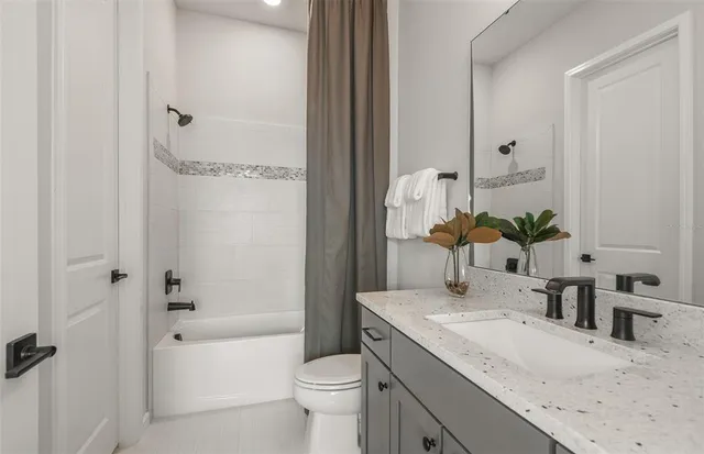 a bathroom with a granite countertop sink a toilet and shower