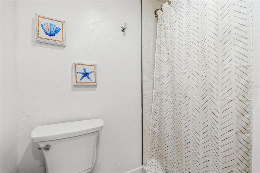 5430 Circle Drive Weeki Wachee, FL 34607 - Photo 26 of 31 a white toilet sitting next to a shower curtain