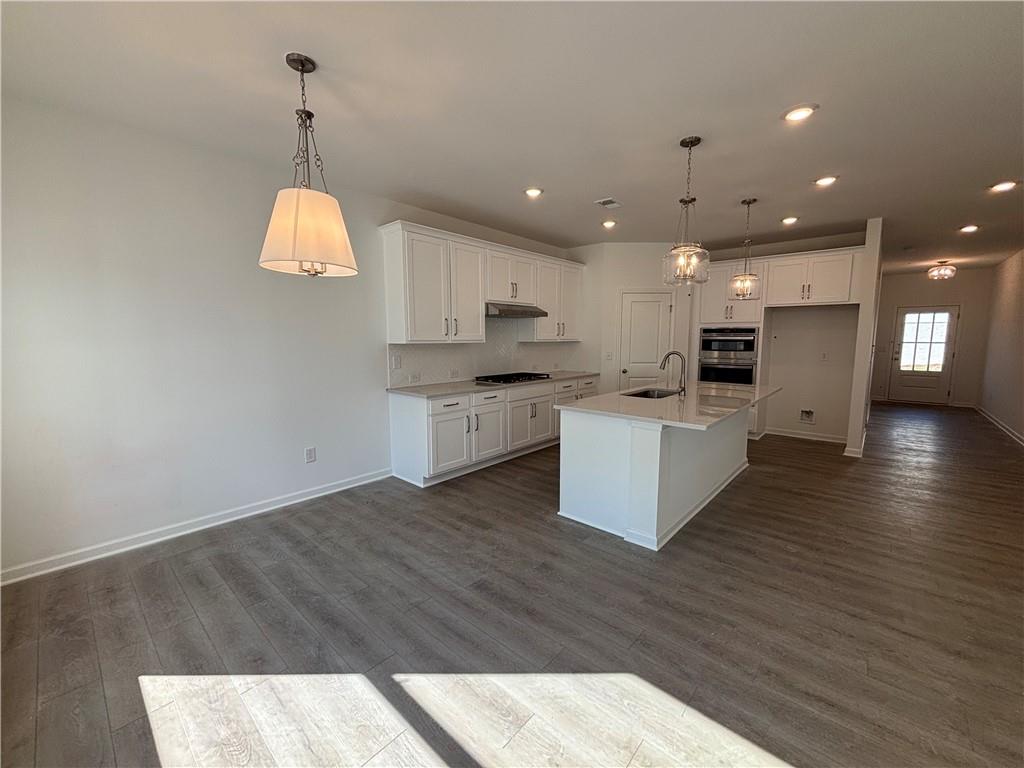 6125 Kismet Road Buford, GA 30518 - Photo 12 of 40 a kitchen with stainless steel appliances kitchen island granite countertop a sink a stove and cabinets