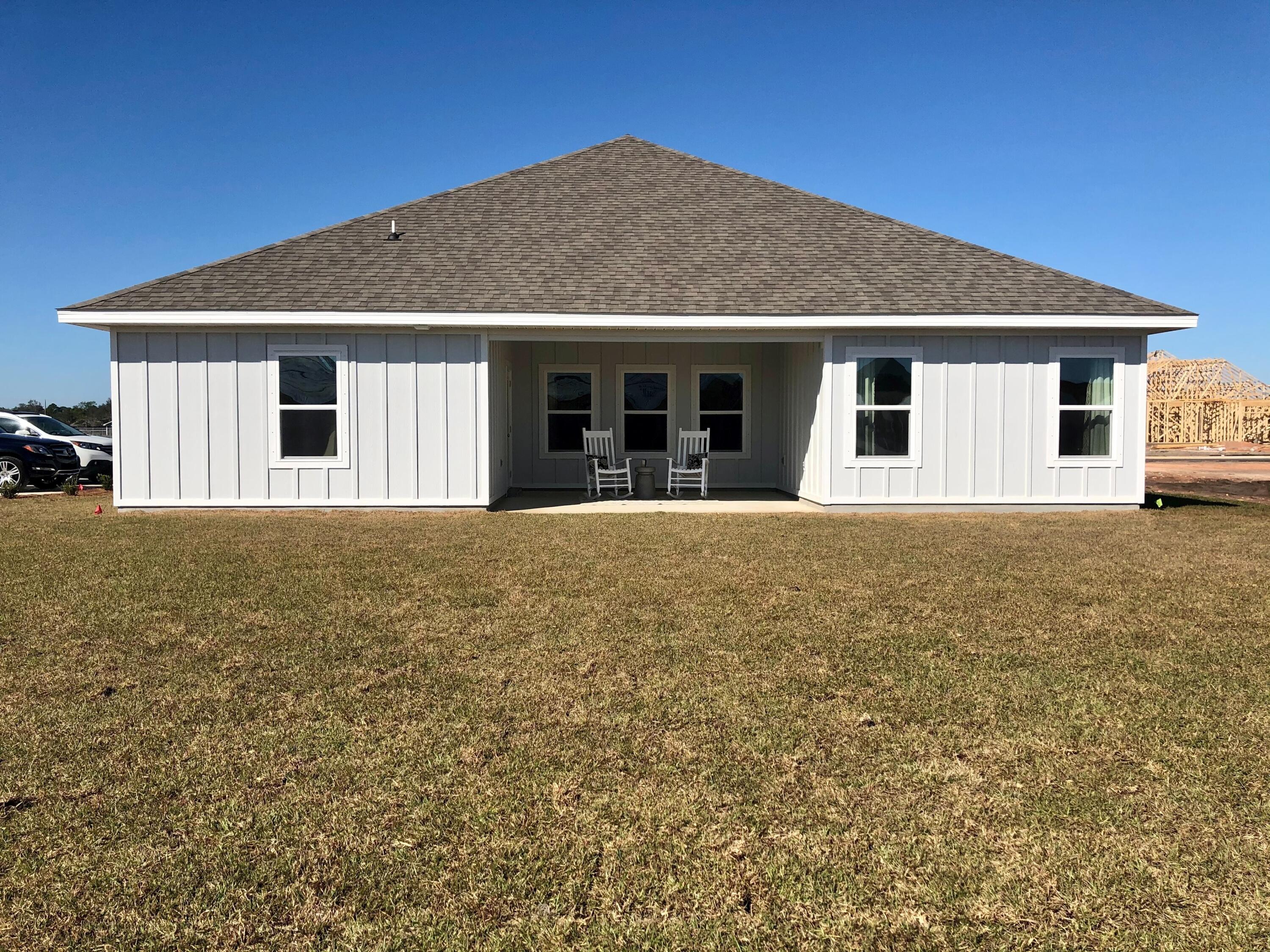 704 Quintana Street Crestview, FL 32539 - Photo 24 of 32 a front view of house with yard and trees in the background