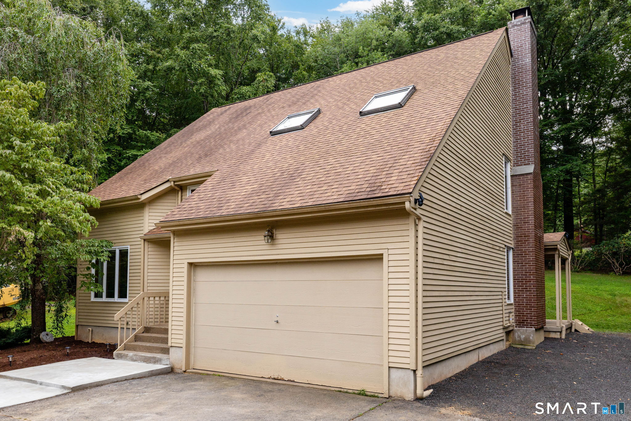 1386 Cedar Swamp Road Coventry, CT 06238 - Photo 7 of 39 Oversized double garage doors with crisp millwork detail complement the home, offering parking for up to six vehicles with room to back up, turn around, and easily exit the driveway.