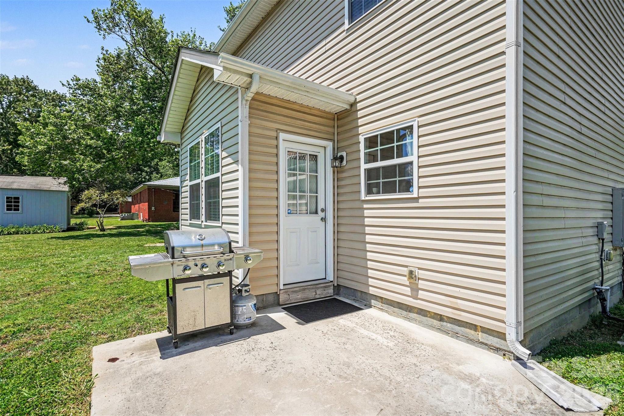 1610 Walter Hasty Road Monroe, NC 28110 - Photo 29 of 32 a backyard of a house with barbeque oven and garden