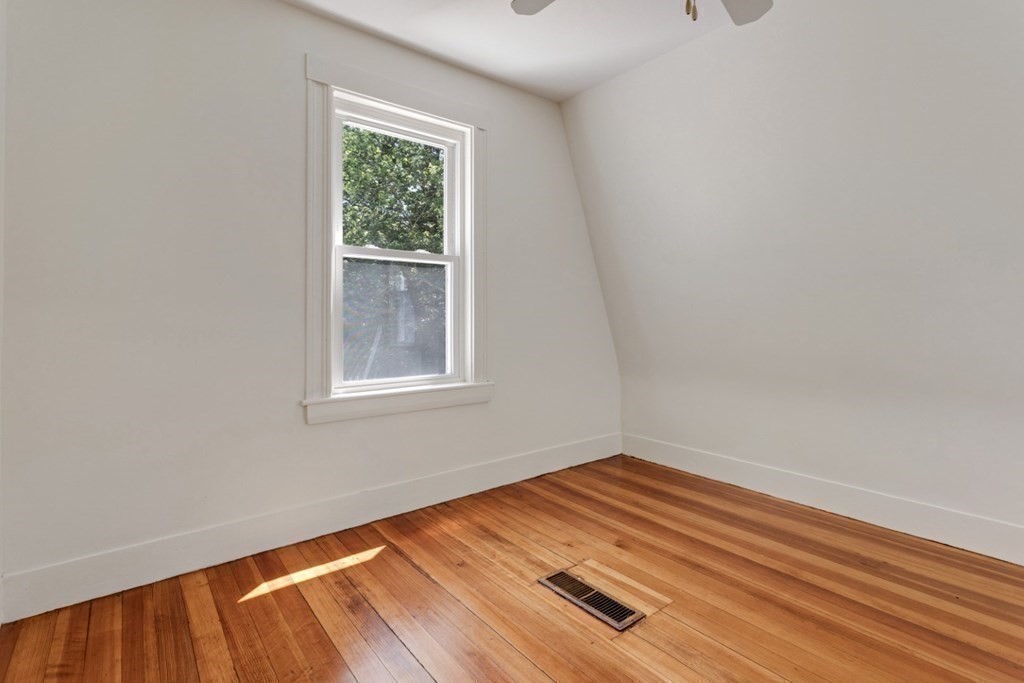 34 Eustis Street Saugus, MA 01906 - Photo 19 of 28 a view of an empty room with wooden floor and a window