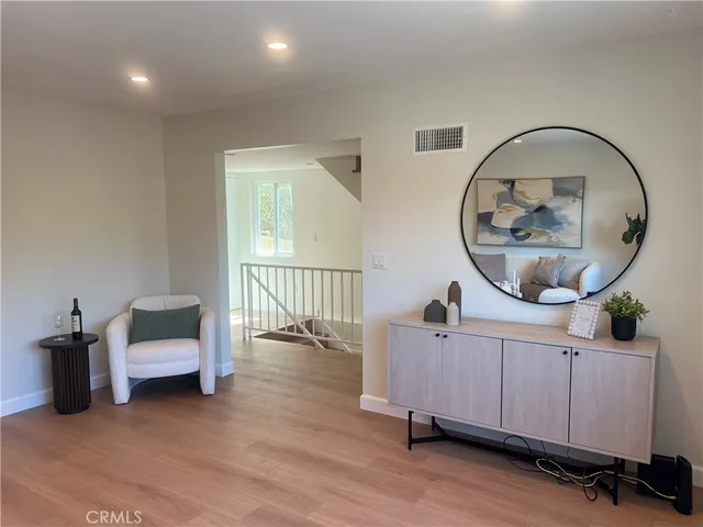 an entryway with wooden floor and windows