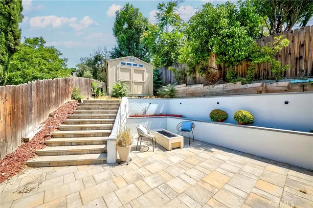 a patio with table and chairs and potted plants