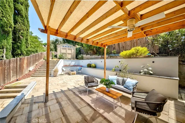 a view of a patio with table and chairs potted plants and a palm tree