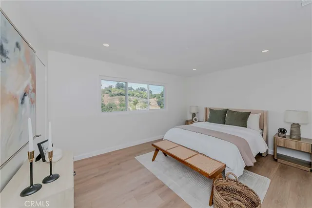 a bed room with a bed a mirror and a window