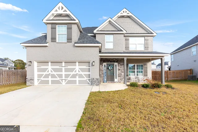 a front view of a house with a yard outdoor seating and garage