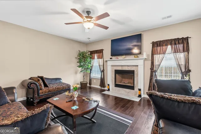 a living room with furniture a flat screen tv and a fireplace