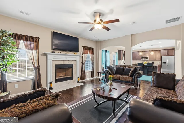 a kitchen with stainless steel appliances granite countertop a refrigerator oven a sink dishwasher a dining table and chairs with wooden floor