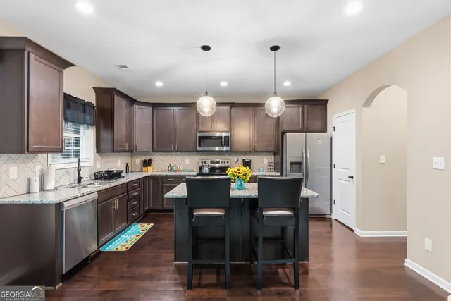 a kitchen with stainless steel appliances granite countertop a sink stove and cabinets
