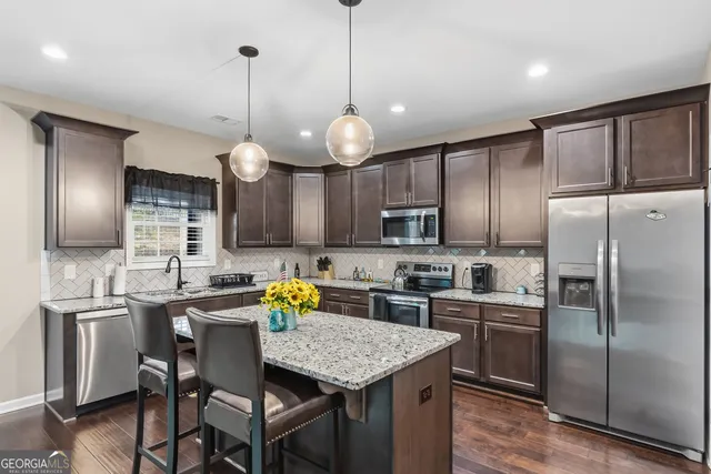 a kitchen with stainless steel appliances granite countertop a sink stove and microwave