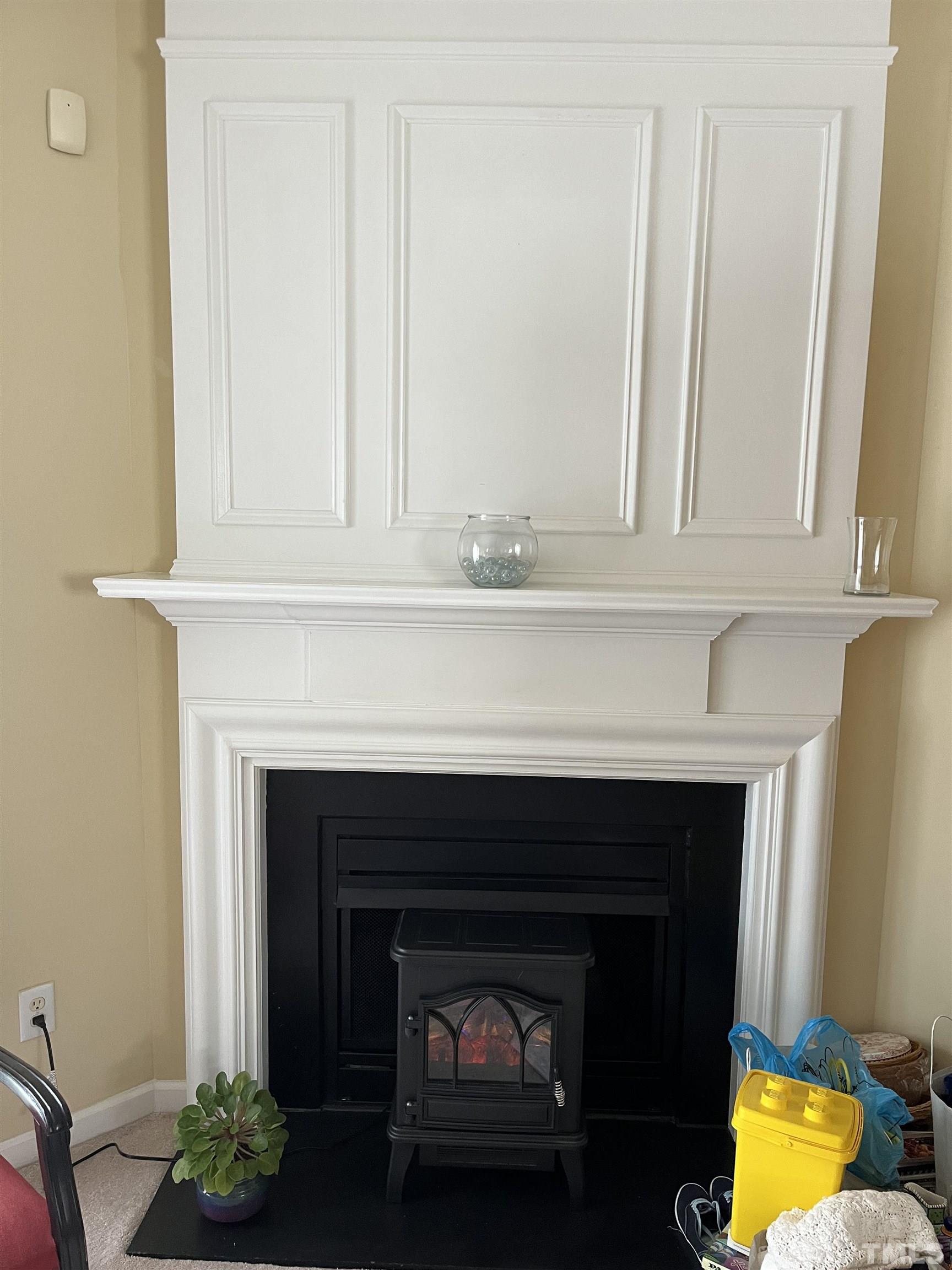 5309 Glen Canyon Road Raleigh, NC 27616 - Photo 5 of 11 a fireplace with a clock on the wall