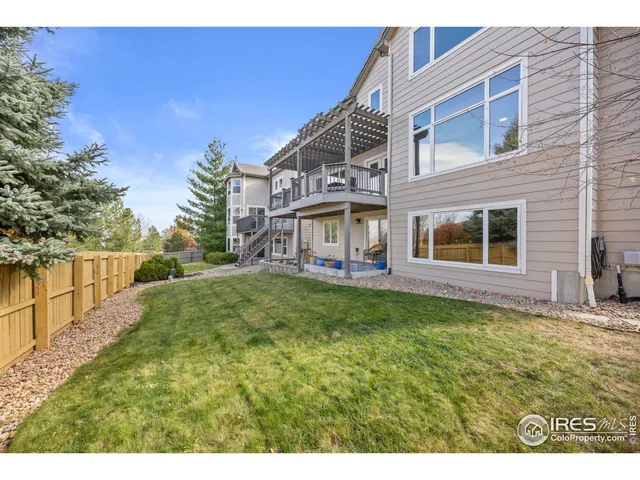 a view of a house with a big yard and large tree