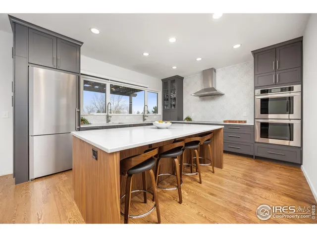 a kitchen with kitchen island a counter top space stainless steel appliances and cabinets