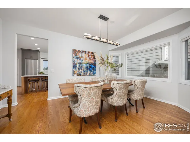 a dining room with furniture a chandelier and wooden floor