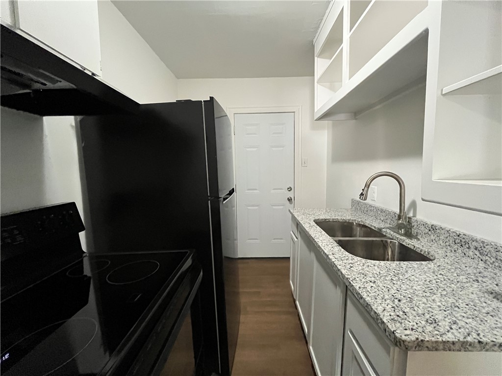 907 Elizabeth Street, Unit 2 Corpus Christi, TX 78404 - Photo 5 of 11 a kitchen with a refrigerator and a sink