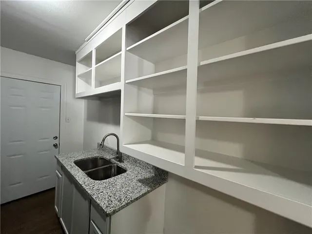 a kitchen with granite countertop a sink and cabinets