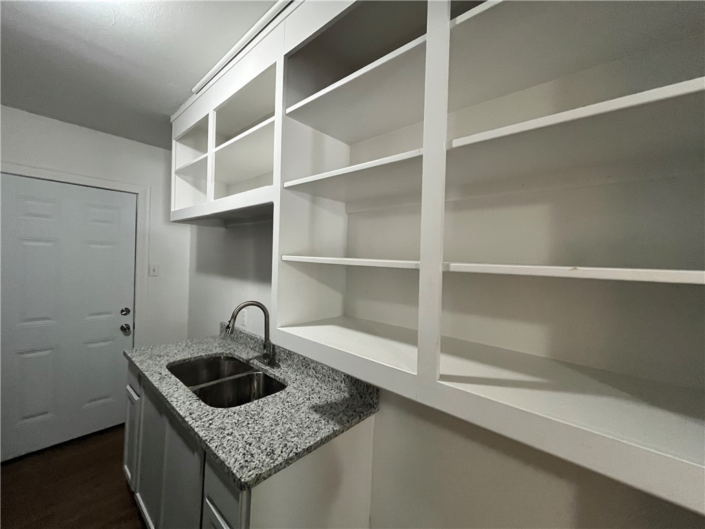 907 Elizabeth Street, Unit 2 Corpus Christi, TX 78404 - Photo 6 of 11 a kitchen with granite countertop a sink and cabinets