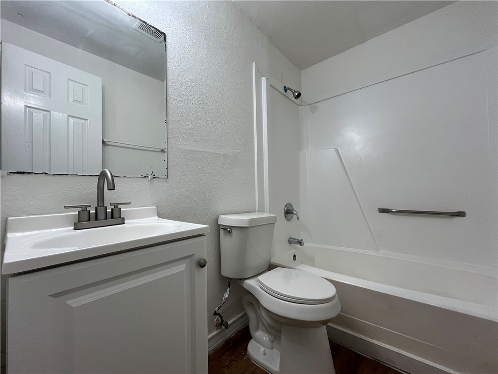 907 Elizabeth Street, Unit 2 Corpus Christi, TX 78404 - Photo 8 of 11 a bathroom with a sink a toilet and shower