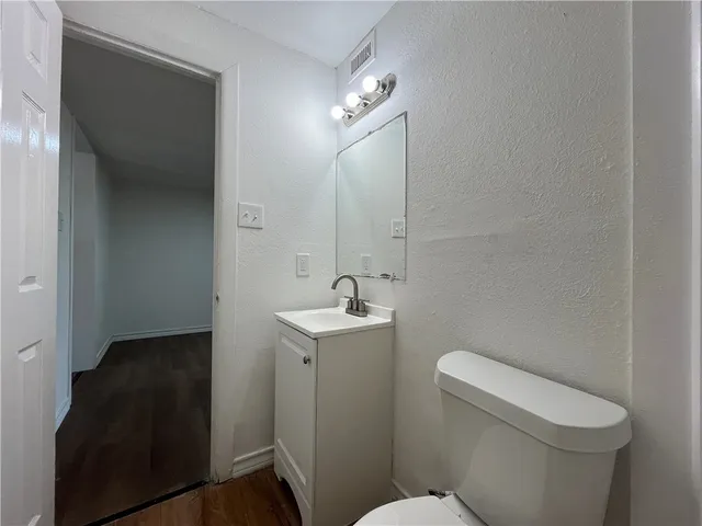 a bathroom with a toilet a sink and mirror