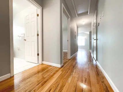 a view of a room with wooden floor and a bathroom