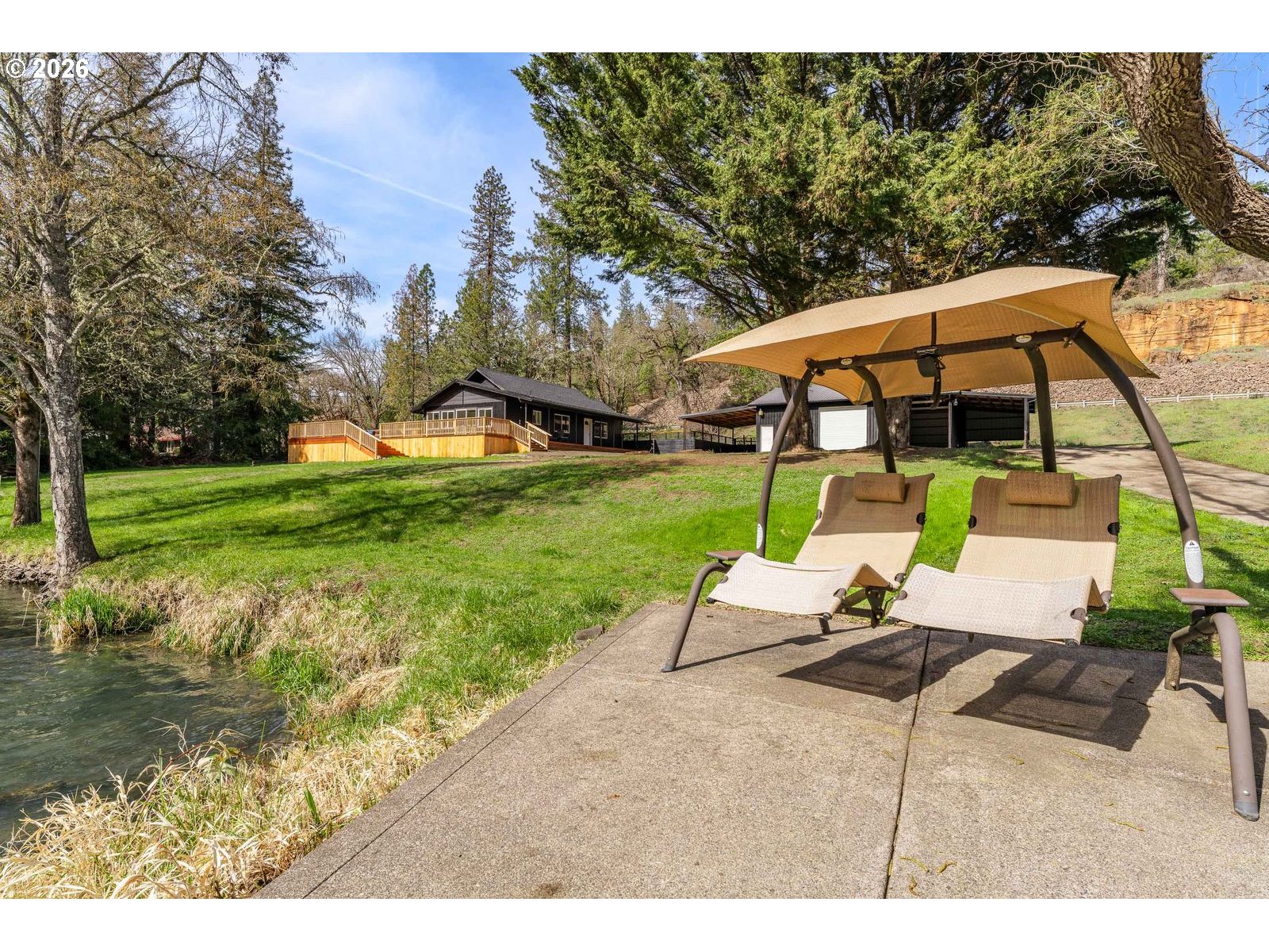24990 Highway 62 Trail, OR 97541 - Photo 14 of 23 a view of a patio with a table and chairs under an umbrella