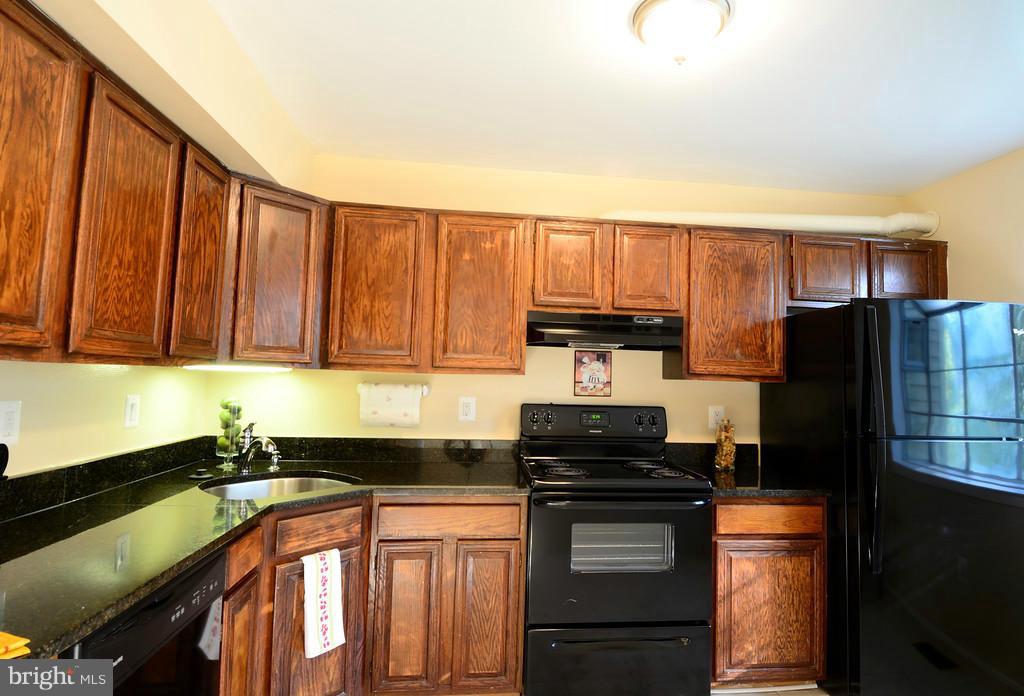 2330 Hunters Square Court Reston, VA 20191 - Photo 12 of 30 a kitchen with stainless steel appliances granite countertop a refrigerator stove and sink