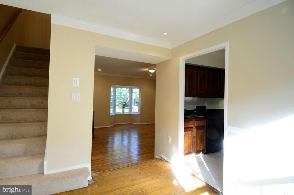 2330 Hunters Square Court Reston, VA 20191 - Photo 4 of 30 a view of a hallway with wooden floor and a living room