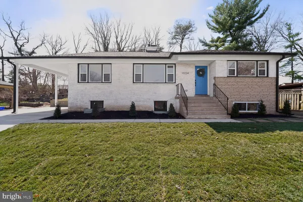 a view of a house with backyard and a tree