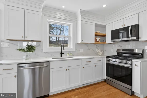 a kitchen with white cabinets stainless steel appliances and sink