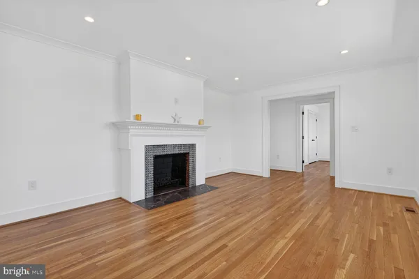 a view of empty room with wooden floor and fireplace