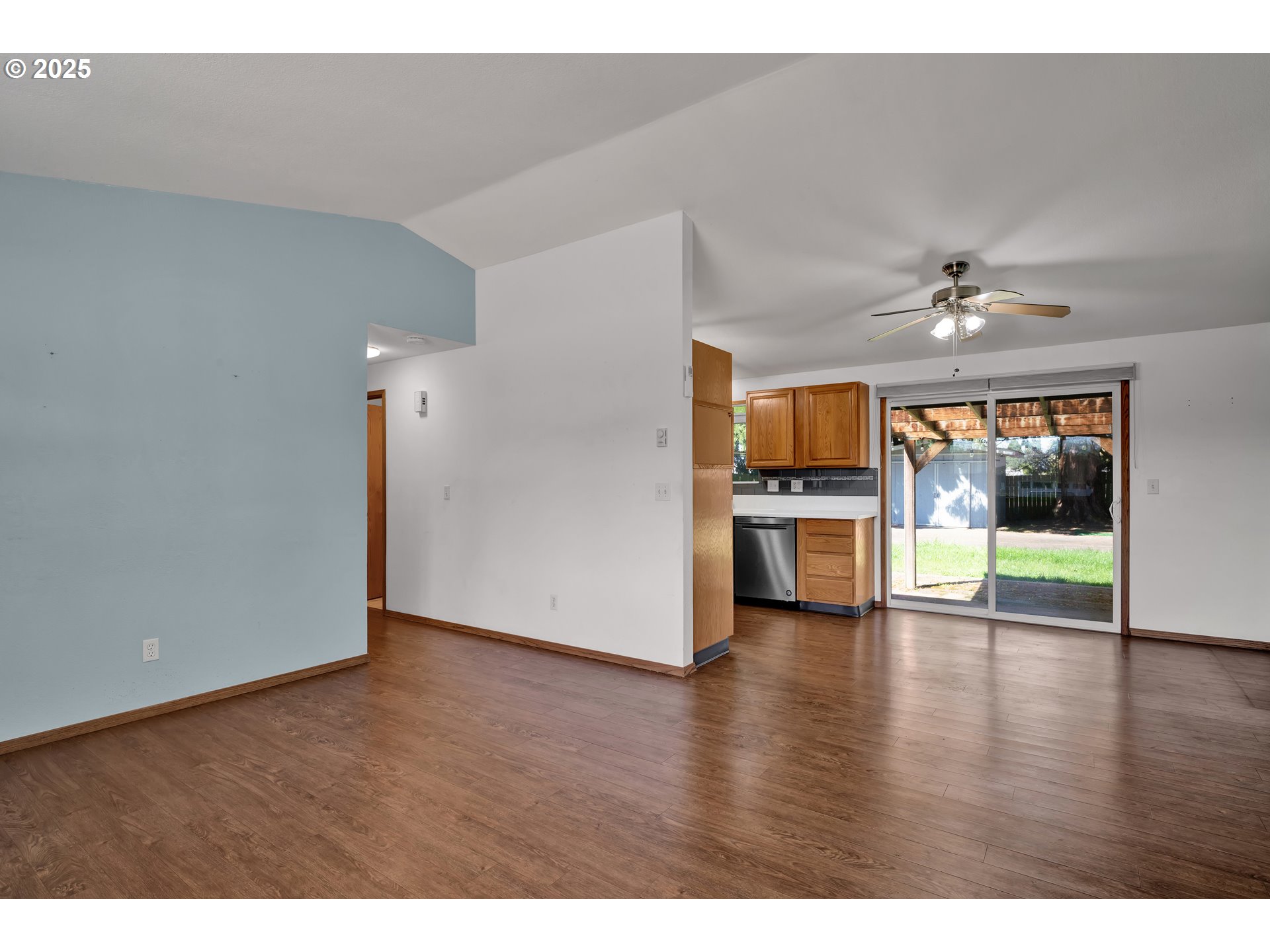 3760 Cherokee Drive Springfield, OR 97478 - Photo 12 of 42 a view of an empty room with wooden floor and a kitchen