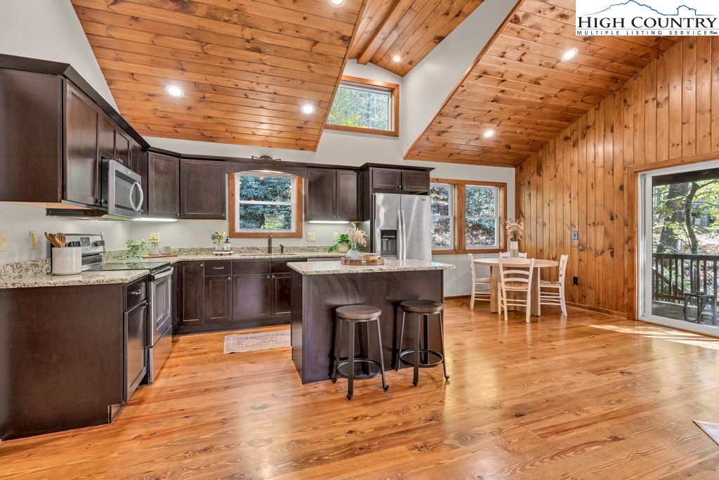 359 Sorrento Falls Road Blowing Rock, NC 28605 - Photo 11 of 46 a kitchen with stainless steel appliances kitchen island granite countertop a table chairs and a oven