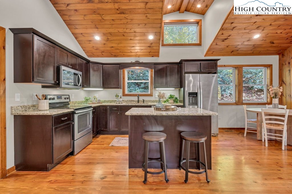 359 Sorrento Falls Road Blowing Rock, NC 28605 - Photo 12 of 46 a kitchen with stainless steel appliances granite countertop a stove top oven a sink dishwasher a dining table and chairs with wooden floor