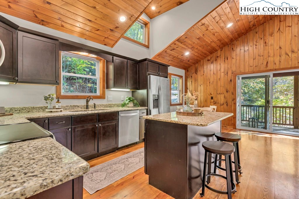359 Sorrento Falls Road Blowing Rock, NC 28605 - Photo 13 of 46 a kitchen with stainless steel appliances granite countertop sink stove and wooden cabinets