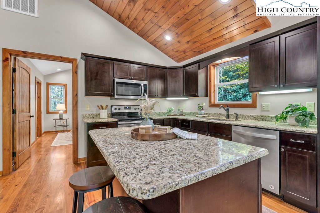 359 Sorrento Falls Road Blowing Rock, NC 28605 - Photo 14 of 46 a kitchen with granite countertop kitchen island a large counter top space appliances and a center island