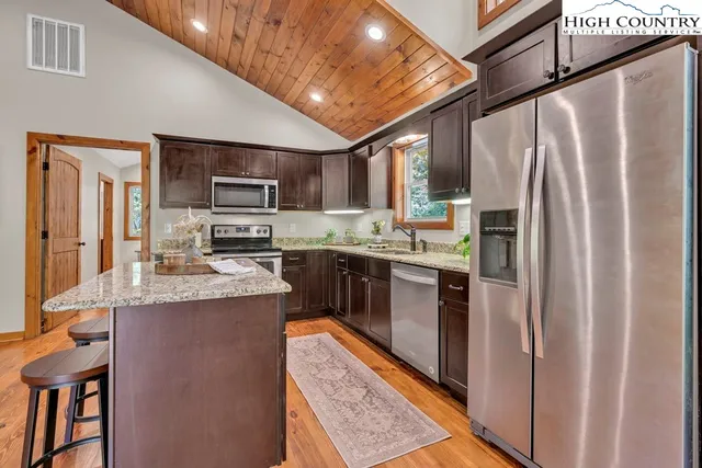 a kitchen with stainless steel appliances granite countertop a refrigerator a stove a sink dishwasher and a microwave oven