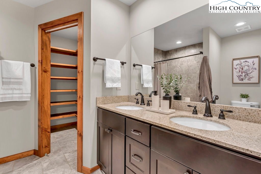 359 Sorrento Falls Road Blowing Rock, NC 28605 - Photo 23 of 46 a bathroom with a granite countertop sink and a mirror