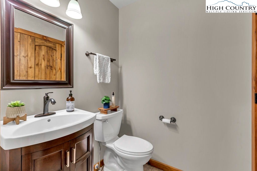 359 Sorrento Falls Road Blowing Rock, NC 28605 - Photo 27 of 46 a bathroom with a toilet a sink and mirror