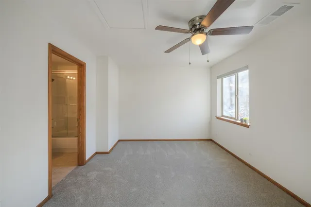 an empty room with fan and windows